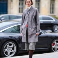 Model wears a gray long coat, shorts, tights, black leather loafers shoes, outside Chanel, during the Womenswear Fall/Winter 2024/2025 as part of...