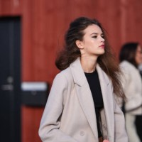 Model wears a white long coat , a black cropped top, red lipstick , make-up , outside Gestuz, during the Copenhagen Fashion Week AW24 on February 01,...