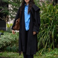 Model Xu Wei is seen wearing a black trench coat, blue shirt, black pants and tan shoes and brown bag outside the Zimmermann show during the...