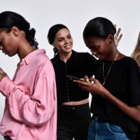 Models check their mobile phone as they wait in the backstage before the Philosophy di Lorenzo Serafini fashion show, as part of the Women's...