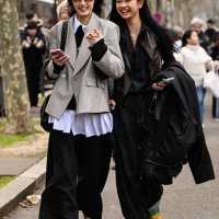 Models Xiaohan Chen and Yu Gue are seen wearing a gray jacket and brown jacket outside the Miu Miu show during the Womenswear Fall/Winter 2025/2026...