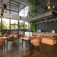 modern coffee shop interior with tables, coffee maker, pastries and walled garden - garden decoration stock pictures, royalty-free photos & images