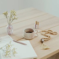 modern still life at home coffee cup note book zen buddha necklace and pen on table - home decoration stock pictures, royalty-free photos & images