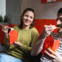 modern young couple enjoy the chinese take out food, while sitting on the floor - junk food stock pictures, royalty-free photos & images