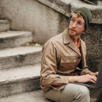 moderner mann mit laptop auf stufen in der stadt - fashion stock-fotos und bilder