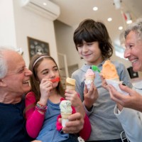mooie grootouders delen van tijd met hun kleinkinderen op het ijs salon - junk food stockfoto's en -beelden