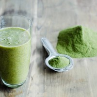 moringa powder on spoon and wooden table and glass of moringa smoothie - food fotografías e imágenes de stock