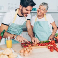 mother and adult son making salad together - food stock pictures, royalty-free photos & images