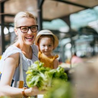 mother and daughter buying lettuce at the green market - food stock pictures, royalty-free photos & images