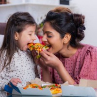 mother and daughter eating pizza stock photo - junk food stock pictures, royalty-free photos & images