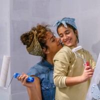 mother and daughter painting a wall of her house together - home decoration stock pictures, royalty-free photos & images