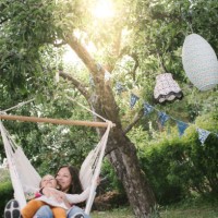 mother and daughter smiling while swinging on hammock in backyard - garden decoration stock pictures, royalty-free photos & images