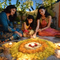 mother and daughters lighting lamps around rangoli made using petals - home decoration stock pictures, royalty-free photos & images