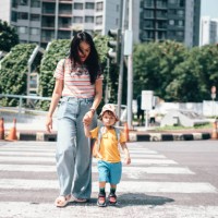 mother and son carrying rucksack walking on zebra crossing on way to school - fashion stock pictures, royalty-free photos & images