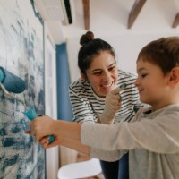 mother and son having fun while painting a room - home decoration stock pictures, royalty-free photos & images