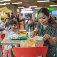 mother checking shopping bags on chair while daughter eating fast food at food court - junk food stock pictures, royalty-free photos & images