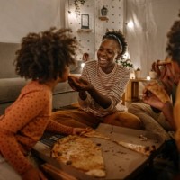 mother feeding pizza to daughter - junk food stock pictures, royalty-free photos & images
