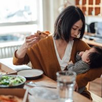 mother having pizza for lunch while playing with her baby at home - junk food stock pictures, royalty-free photos & images