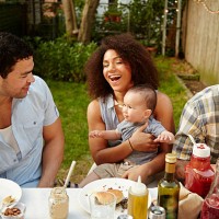mother holding baby boy at table at garden party - garden decoration photos et images de collection