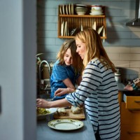 mother serving lunch with daughter in kitchen - food stock pictures, royalty-free photos & images