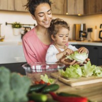 mother with daughter cooking together at kitchen. making fresh salad with greens and organic farm vegetables - food stock pictures, royalty-free photos & images