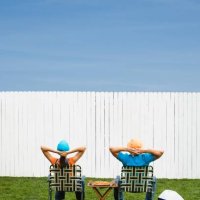 multi-ethnic couple looking at newly painted fence - garden decoration stock pictures, royalty-free photos & images