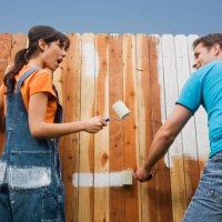 multi-ethnic couple painting fence - garden decoration stock pictures, royalty-free photos & images