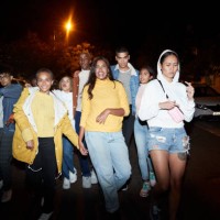 multi-ethnic friends walking on street in city at night - fashion stock pictures, royalty-free photos & images