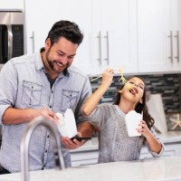 multiracial girl, father eat chinese take out in kitchen - junk food stock pictures, royalty-free photos & images