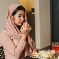 muslim woman reciting a prayer before iftar. - food fotografías e imágenes de stock