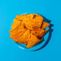 nachos on a blue colored plastic plate - junk food stock-fotos und bilder