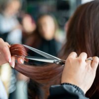 nahaufnahme eines nicht wiederzuerkennbaren friseurs, der einer kundin die haare schneidet - hairstyle stock-fotos und bilder