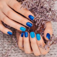 nails of women covered in blue lacquer different shades with rhinestones and with flowers in his hand. - nails art stock pictures, royalty-free photos & images