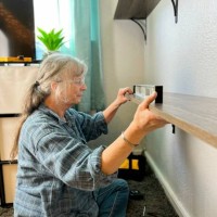 nette seniorin, die regale mit werkzeugen im schlafzimmer aufstellt. - home decoration stock-fotos und bilder