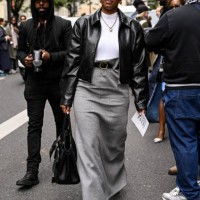 Nicole Martine Chapoteau is seen wearing a black faux leather jacket, white shirt, gray skirt, black and gold buckle belt and black shoes with black...