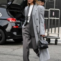 Nicole Warne is seen wearing a light gray coat, gray suit, white top and black sunglasses with black chain Chanelbag outside the Jason Wu show during...