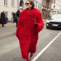Nina Sandbech wears red tights, red shoes, red bag, red fur coat, and red sunglasses outside Aeron during the Copenhagen Fashion Week AW24 on January...