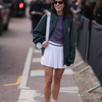 Nina Urgell Cloquell seen wearing a white tennis skirt, green and black checkered Lacoste jacket, purple shirt, black shades, black leather loafer,...