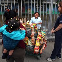 Nurse practitioner Anne Traynor, right, talks to 8-year-old Dafne Sanchez, center, who wanted to buy junk food from a vendor, at left, after she got...