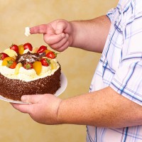 obese man holding fruit gâteaux with cream on - junk food stock pictures, royalty-free photos & images