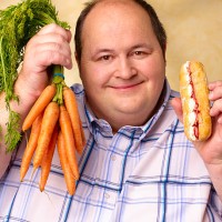 obese man with cream cake and carrots. - junk food stockfoto's en -beelden