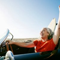 older caucasian woman in convertible car with surfboard on beach - travel stock pictures, royalty-free photos & images
