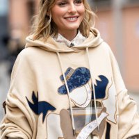 Olivia Palermo is seen wearing a white cream and black printed shirt and a beige hoodie embellished with patches on the front outside Antonio Marras...