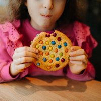 one little girl eating candy cookie - junk food stock pictures, royalty-free photos & images