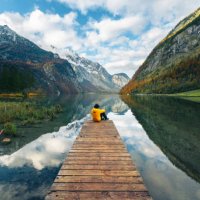 one man sitting on a boat pier admiring the konigssee lake, bavaria, germany - travel stock pictures, royalty-free photos & images