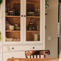opened white glass cabinet with clean dishes and decor. scandinavian style kitchen interior. organization of storage in kitchen. - home decoration stock pictures, royalty-free photos & images