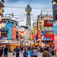 osaka tower und blick auf die neon-werbung in shinsekai bezirk in der dämmerung, osaka, japan - travel stock-fotos und bilder