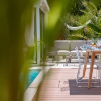 outdoor garden living space with dining table setting on wood terrace patio next to swimming pool - garden decoration stock pictures, royalty-free photos & images