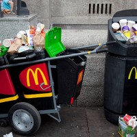 Overflowing bins full of rubbish, waste from a nearby MacDonalds fast food store. At Waterloo, the tourists flock in huge crowds, buying junk food...