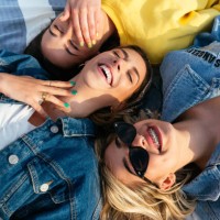 overhead portrait of smiling friends having fun lying on the beach - fashion stock pictures, royalty-free photos & images
